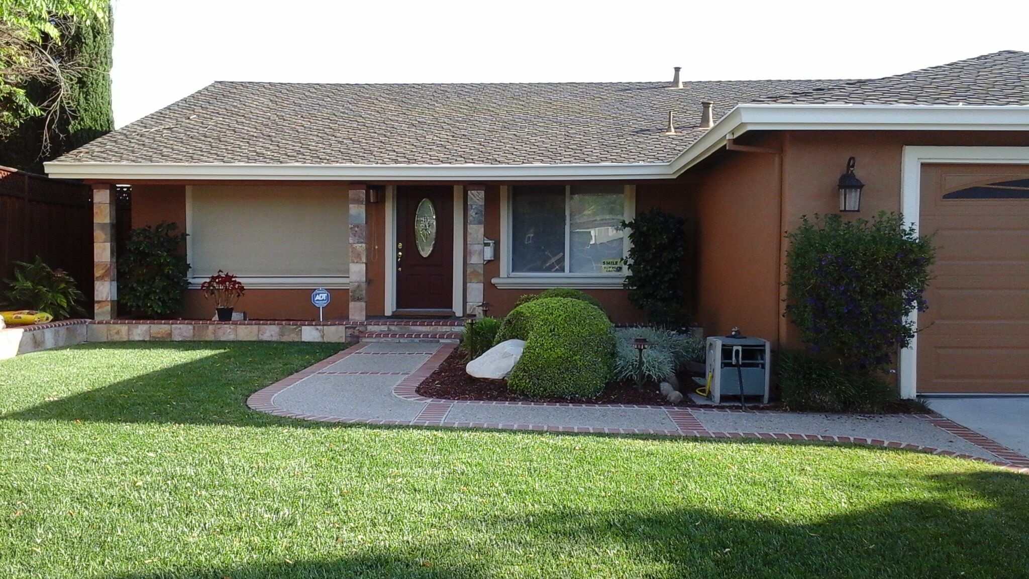 Single-story home with a painted exterior, white trim, and landscaped lawn